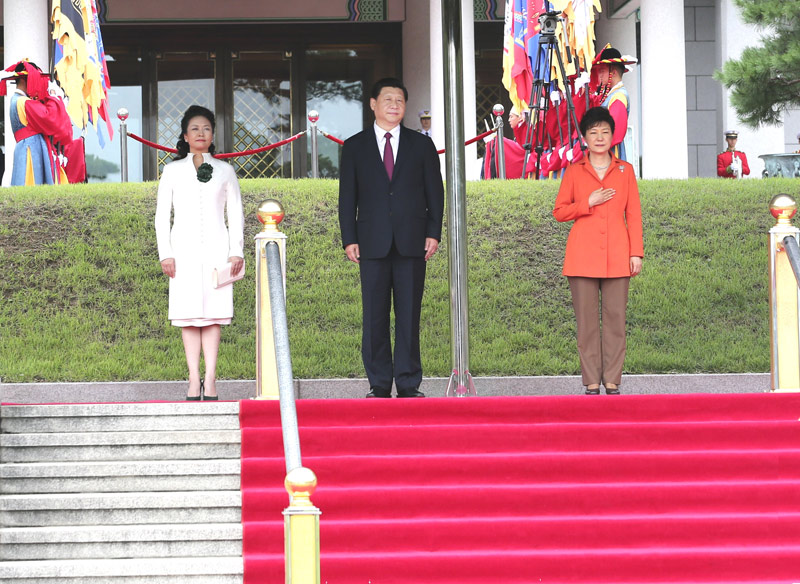 7月3日，韓國總統樸槿惠在青瓦臺總統府舉行隆重儀式，歡迎中國國家主席習近平對韓國進行國事訪問。這是習近平和夫人彭麗媛在樸槿惠陪同下登上檢閱臺。軍樂隊奏中韓兩國國歌。新華社記者丁林攝