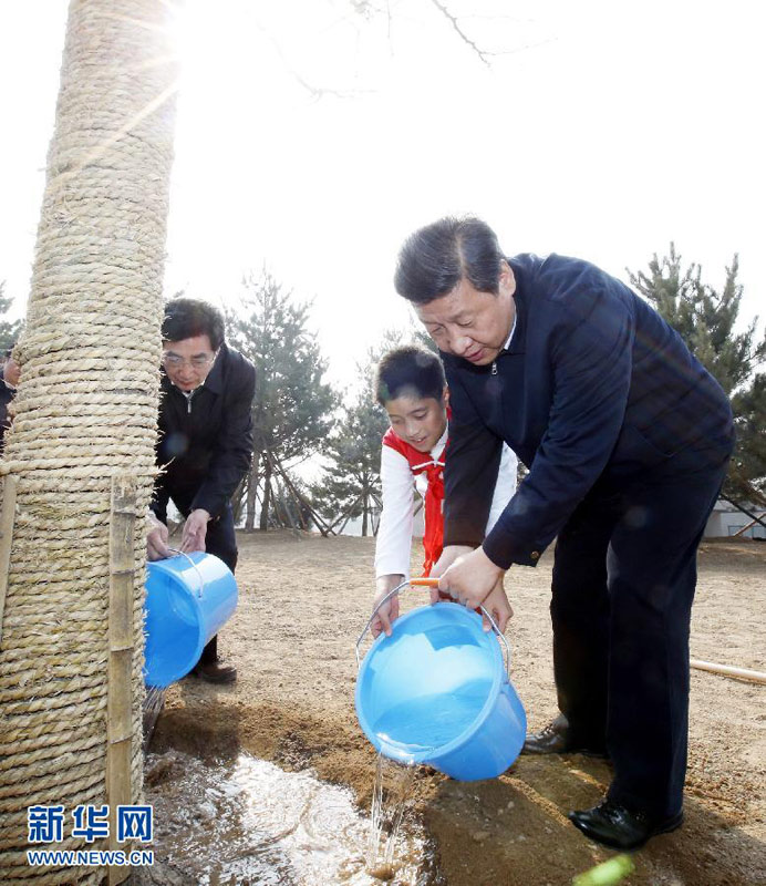 2013年4月2日，黨和國家領導人來到北京市豐臺區永定河畔參加首都義務植樹活動。這是習近平同少先隊員一起給剛栽下的銀杏樹澆水。新華社記者 鞠鵬 攝